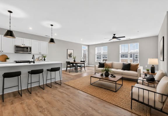 A modern living room with a kitchen area in the background.