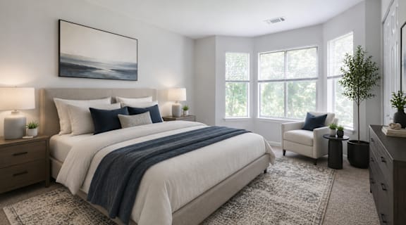 A bedroom with a large bed and a painting on the wall.