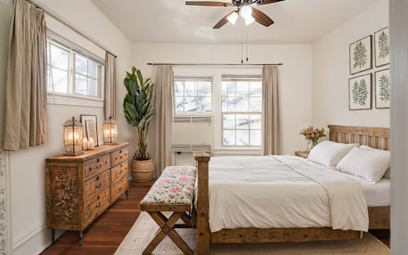 A bedroom with a bed, dresser, and window. at Midtown Apartments, Oregon