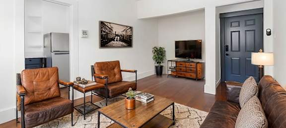 A living room with a brown leather chair and a brown leather couch. at Midtown Apartments, Oregon, 97209