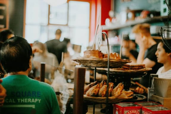 a group of people sitting at a restaurant with food on display