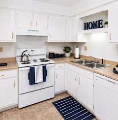 a kitchen with white appliances and white cabinets and a sink