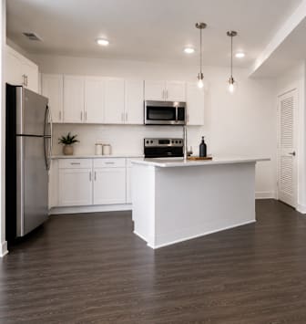 A modern kitchen with white cabinets and a wooden island.