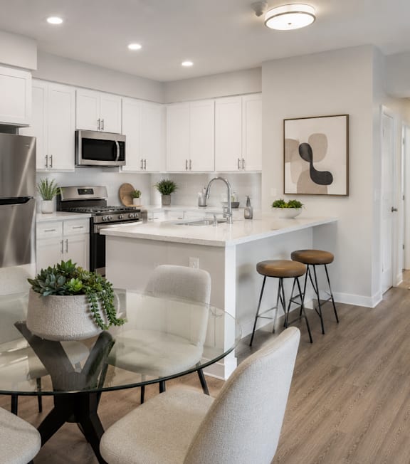 A well-lit, modern kitchen and living room with a dining area.