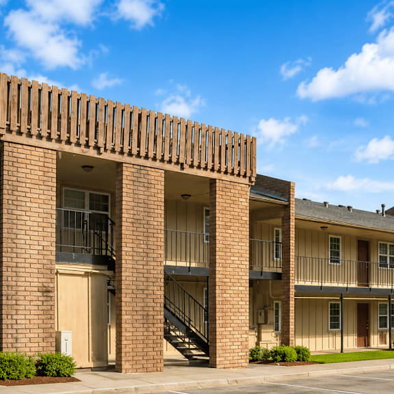 A large brick building with a balcony and stairs leading to the second floor.