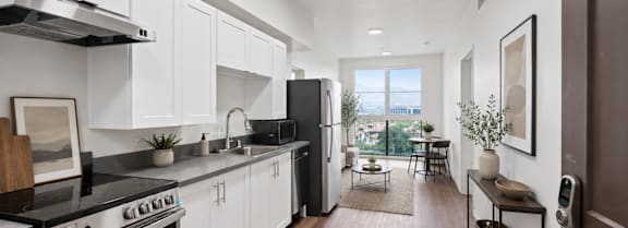 A modern kitchen with white cabinets and a black stove top oven.