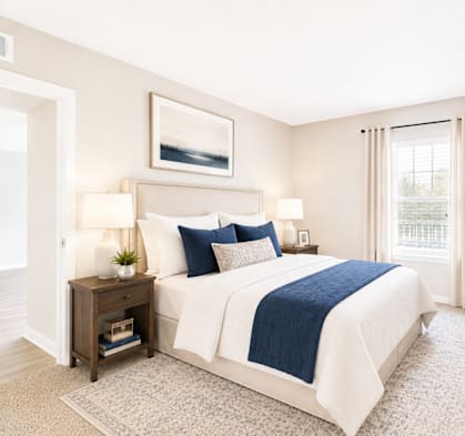 A bedroom with a bed, nightstands, and a window.