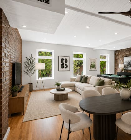A modern living room with a brick wall and a pool table.