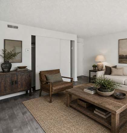 A living room with a white couch, a wooden coffee table, and a painting on the wall.