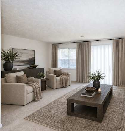 A living room with a large couch, a coffee table, and a painting on the wall.