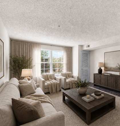 A living room with a couch, a coffee table, and a large window.