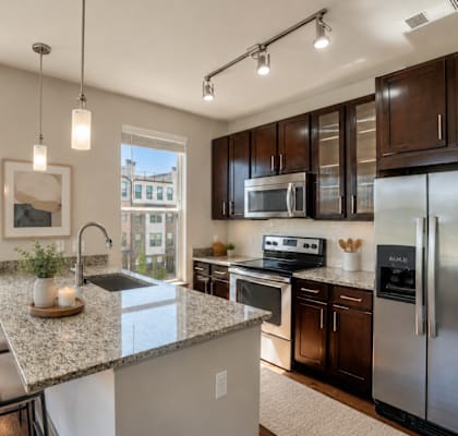 A modern kitchen with a granite countertop and stainless steel appliances.