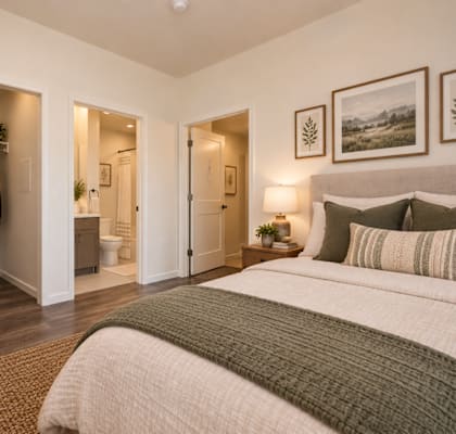 A bedroom with a large bed and a closet with clothes hanging.