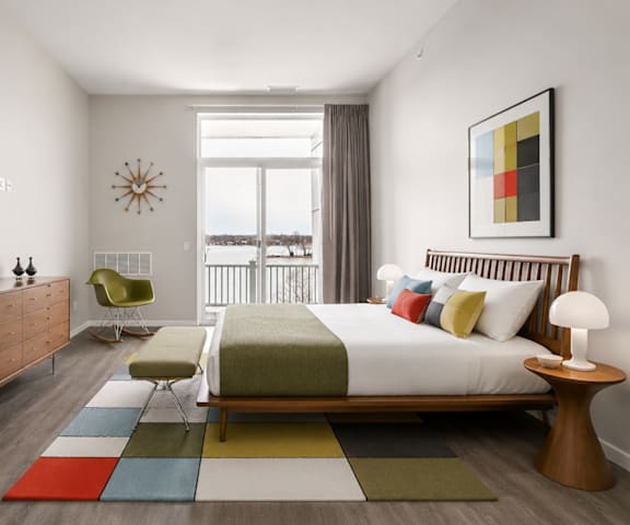 A bedroom with a large bed, a chair, and a dresser.