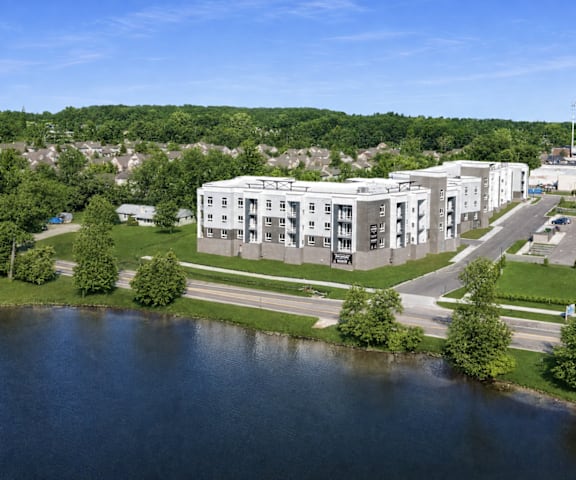 A large white building sits next to a body of water.