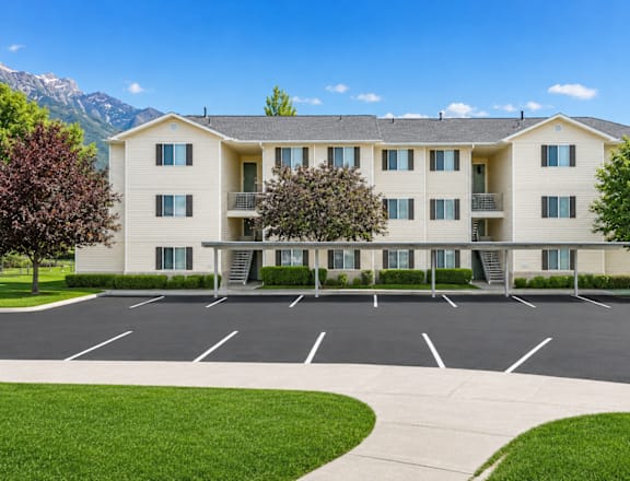 A large apartment complex with a parking lot in front.