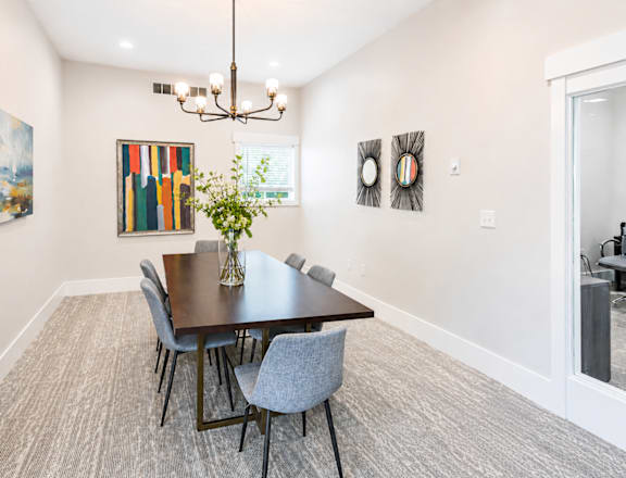 A dining room with a table and chairs.