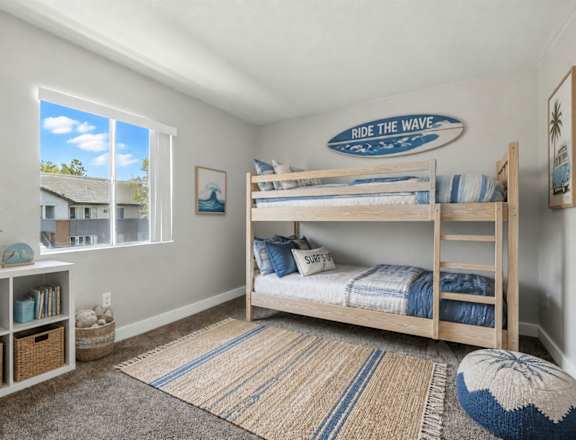 A room with a bunk bed and a surfboard sign on the wall.