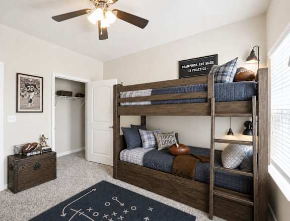 A room with a bunk bed and a chalkboard on the wall.