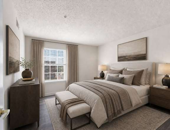 A bedroom with a large bed, a nightstand, and a window with curtains.