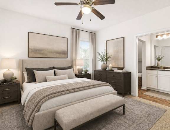 A bedroom with a large bed and a ceiling fan.