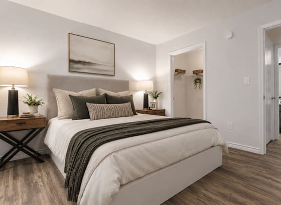 A bedroom with a large bed and a painting on the wall.