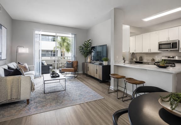 A modern living room with a couch, coffee table, and a kitchen area in the background.