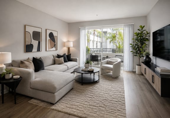 A modern living room with a large couch, a coffee table, and a flat-screen TV.