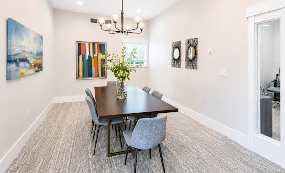 A dining room with a table and chairs.