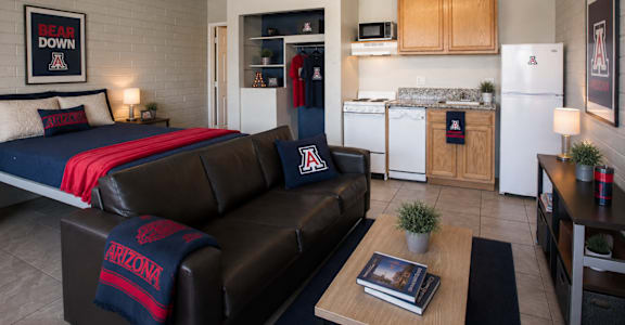 A living room with a couch and a bear down sign on the wall.