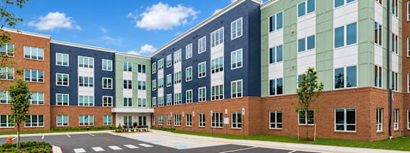 A multi-story building with a parking lot in front.