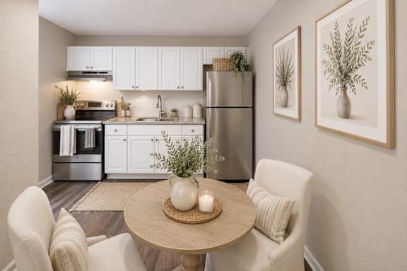 A modern kitchen with a dining table set for two.