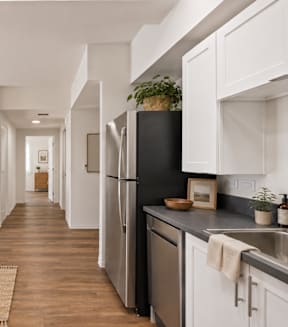 A long hallway with white cabinets on either side.