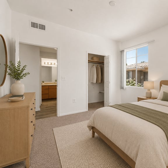 A bedroom with a large bed and a view of a house through the window.