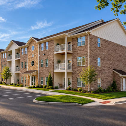 A large apartment complex with a parking lot in front.