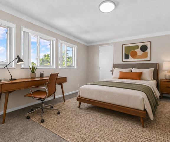 A bedroom with a bed, desk, and chair.