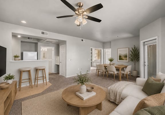 A living room with a white couch, a wooden coffee table, and a ceiling fan.