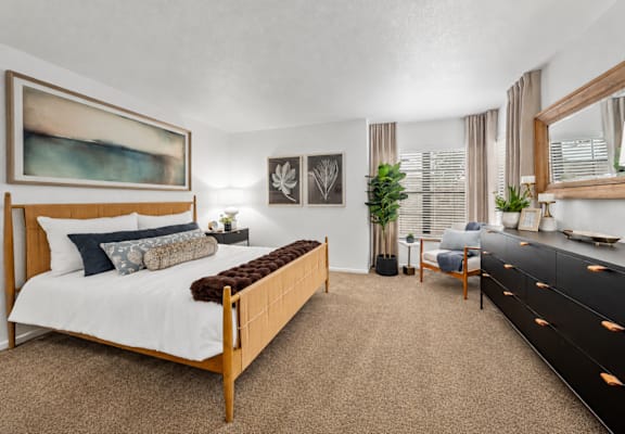 A bedroom with a large bed and a painting on the wall.