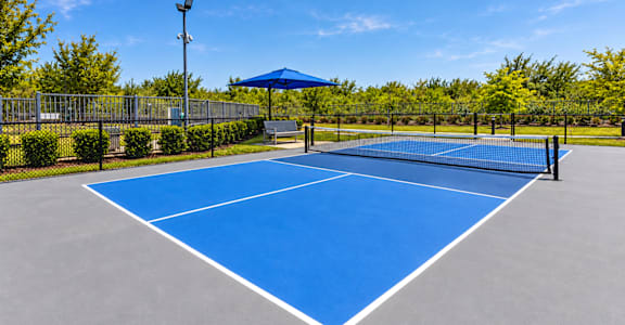 A blue tennis court with white lines and a white canopy.