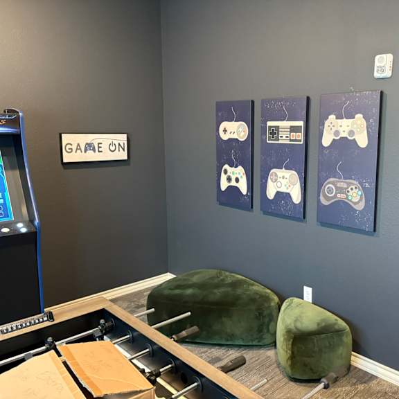 A room with bean bag chairs and a sign that says "Game On".