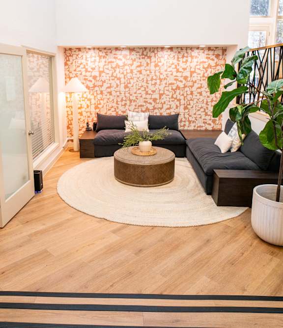 A living room with a grey couch and a wooden coffee table.