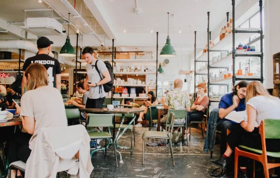 a group of people sitting at tables in a restaurant