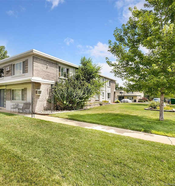 A house with a well-maintained lawn in front of it.