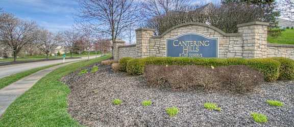 A sign that says "CANTERING HILLS THE RESERVE" is in front of a grassy area.
