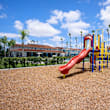 A playground with a blue slide and wooden structure.