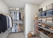 Thumbnail 15 of 22 - A well-organized walk-in closet with neatly arranged clothes and shoes.