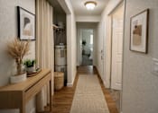 Thumbnail 6 of 8 - A hallway with a wooden bench and a rug on the floor.