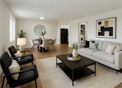 Thumbnail 4 of 8 - A modern living room with a black coffee table and a white sofa.