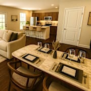 A man in a yellow shirt is sitting at a table with a laptop. at Portrait Midtown Apartments, Indiana, 46032