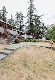 a building with stairs and a yard with trees